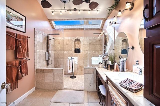 bathroom featuring vanity, ceiling fan, and a tile shower