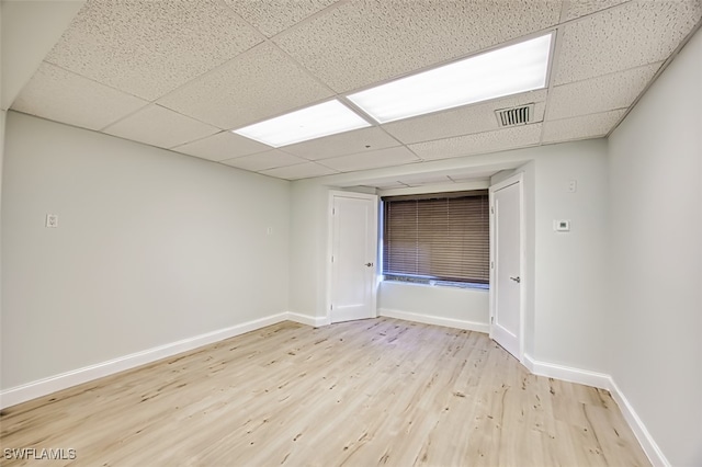 unfurnished room featuring a paneled ceiling and light wood-type flooring