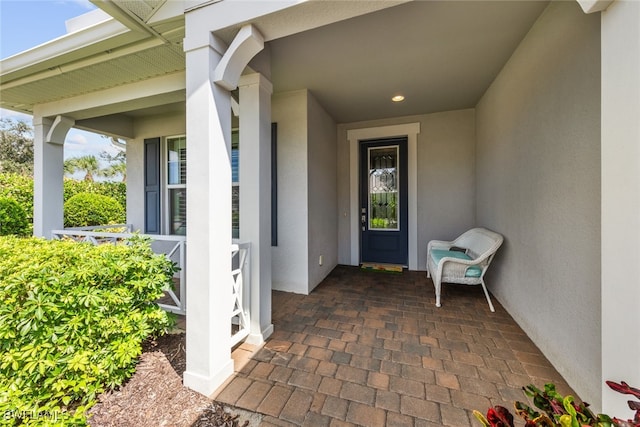 view of exterior entry featuring covered porch