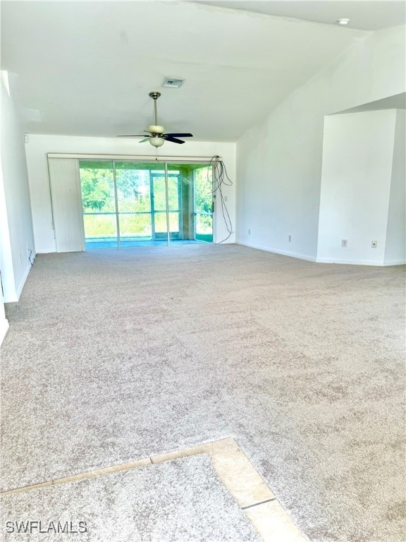 empty room featuring carpet, ceiling fan, and vaulted ceiling