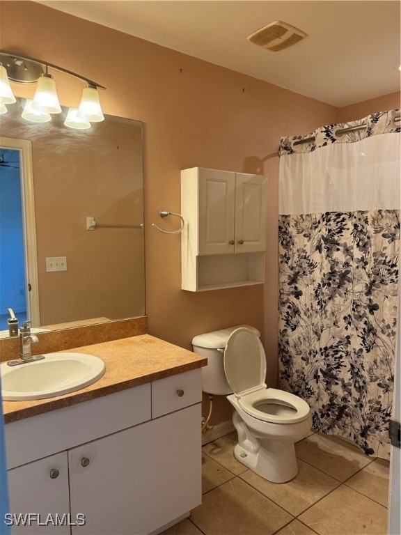 bathroom featuring walk in shower, vanity, tile patterned flooring, and toilet