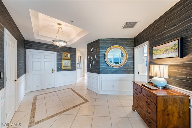 entrance foyer featuring light tile patterned floors and a tray ceiling