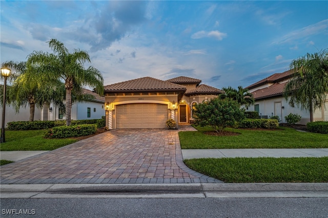 mediterranean / spanish home featuring a front yard and a garage