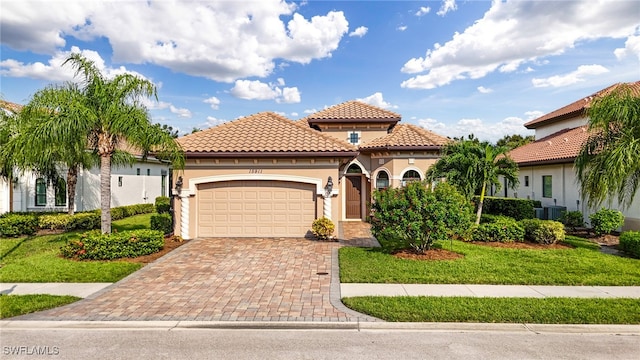 mediterranean / spanish home featuring a front yard and a garage