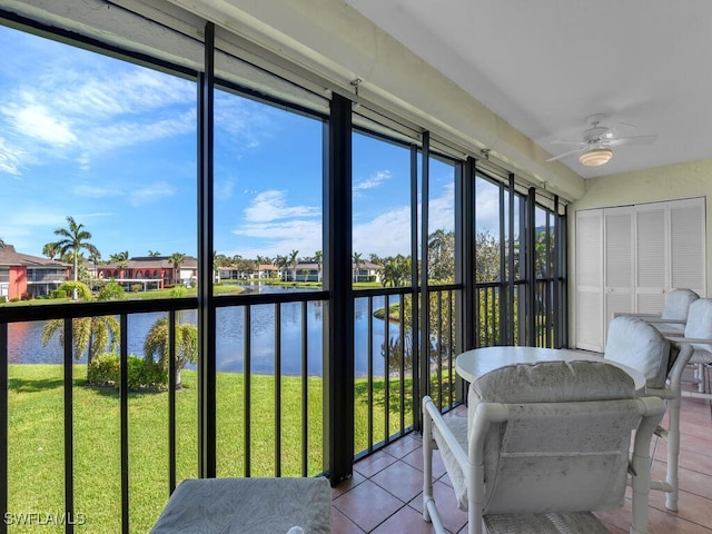 sunroom / solarium with a water view and ceiling fan