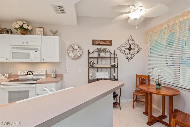 4705 Hawks Nest Way Unit 103, Naples, FL 34114 - kitchen with white cabinets, light tile patterned flooring, visible vents, white appliances, and ceiling fan