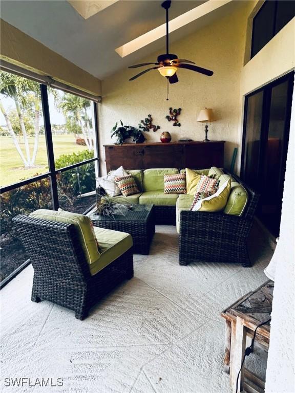 sunroom with ceiling fan and vaulted ceiling