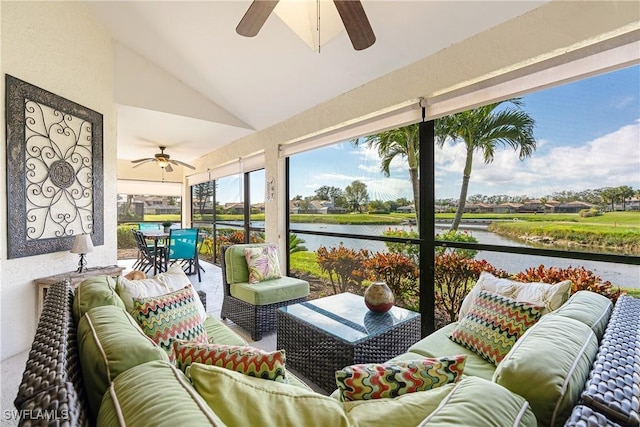 sunroom / solarium featuring lofted ceiling, ceiling fan, and a water view