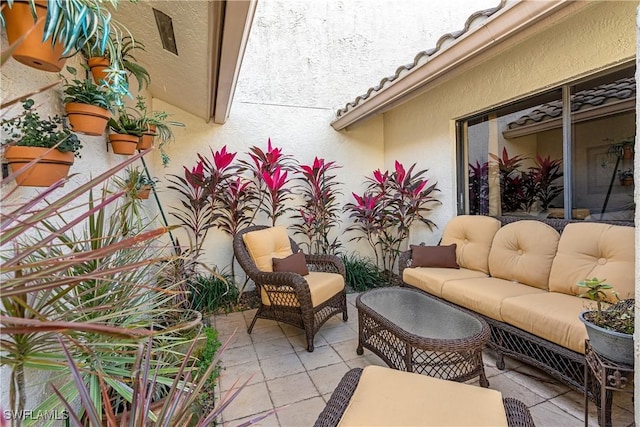 balcony with an outdoor living space and a patio area