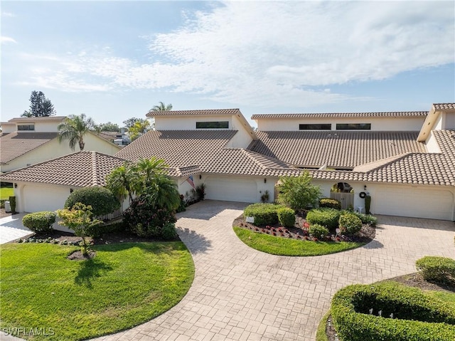 view of front facade featuring a tiled roof, a garage, driveway, and stucco siding