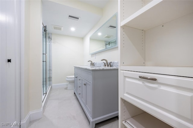 bathroom with vanity, toilet, and a shower with door