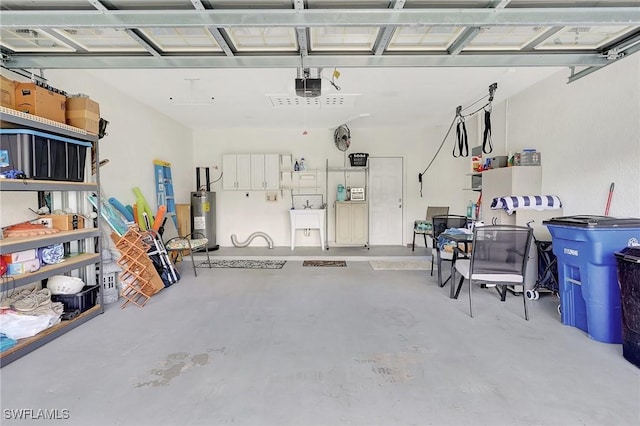 garage featuring sink, a garage door opener, and water heater