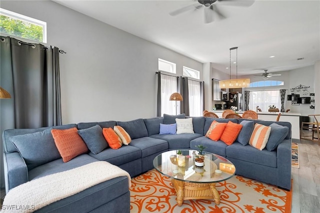 living room with light hardwood / wood-style flooring and ceiling fan