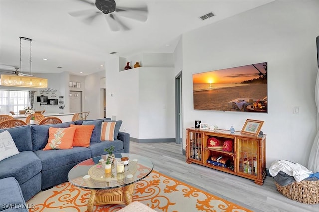 living room with ceiling fan and light hardwood / wood-style flooring