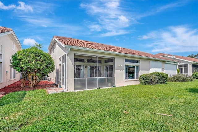 back of house with a yard and a sunroom