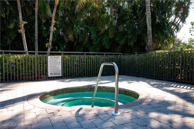 view of swimming pool featuring a hot tub