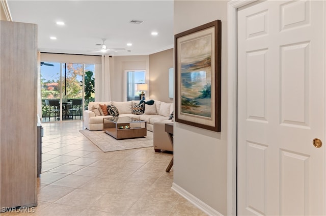 living room with ceiling fan, ornamental molding, and light tile patterned floors