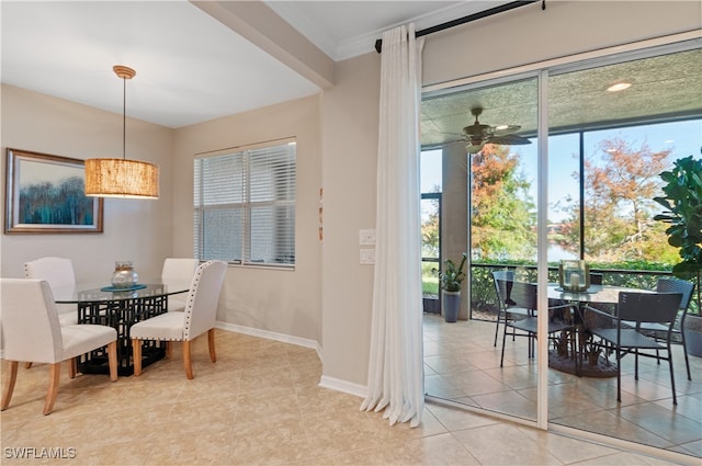 tiled dining space featuring crown molding and ceiling fan