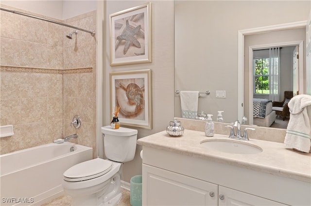 full bathroom featuring tiled shower / bath, vanity, and toilet