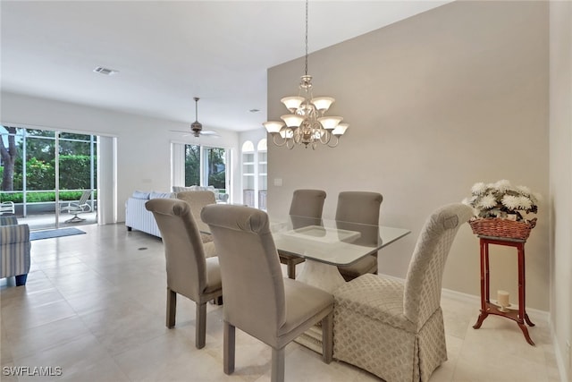 dining area featuring ceiling fan with notable chandelier