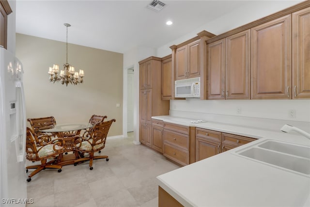 kitchen with white appliances, sink, a chandelier, and decorative light fixtures