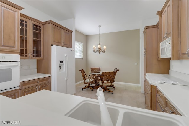 kitchen with sink, a notable chandelier, decorative light fixtures, and white appliances