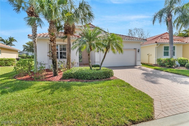 mediterranean / spanish-style home with a front lawn and a garage