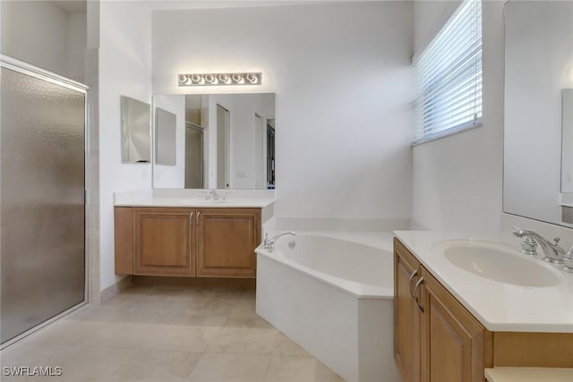 9246 Springview Loop, Estero, FL 33928 - full bathroom with a stall shower, two vanities, a garden tub, and tile patterned flooring