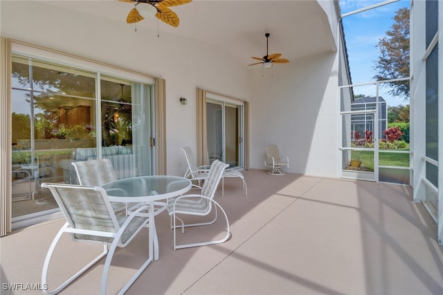 view of patio / terrace featuring ceiling fan and glass enclosure