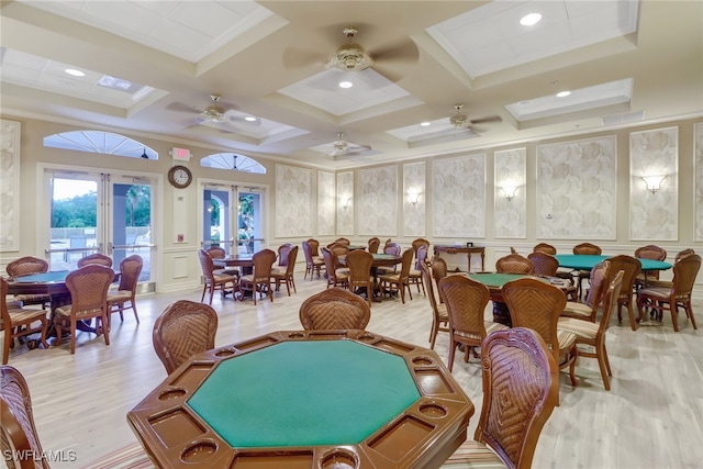 playroom featuring ceiling fan, light hardwood / wood-style flooring, beamed ceiling, french doors, and coffered ceiling