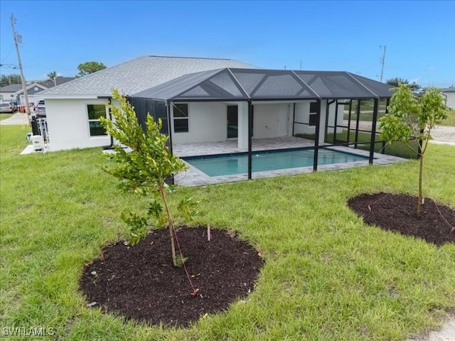 back of property with glass enclosure, a patio area, and a lawn