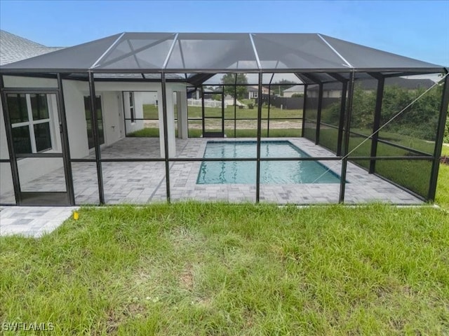 view of swimming pool with a yard, a patio, and glass enclosure