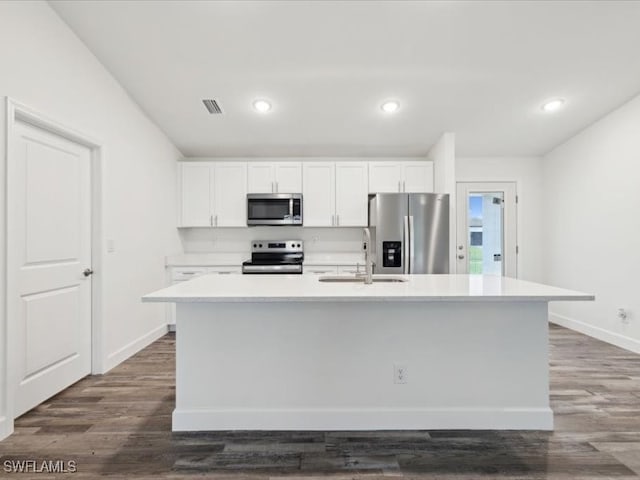 kitchen featuring a center island with sink, appliances with stainless steel finishes, dark hardwood / wood-style flooring, white cabinets, and sink