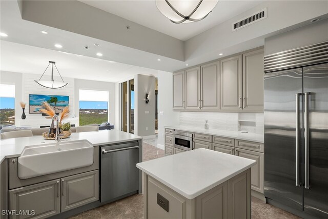 kitchen featuring a center island, a healthy amount of sunlight, stainless steel appliances, and sink