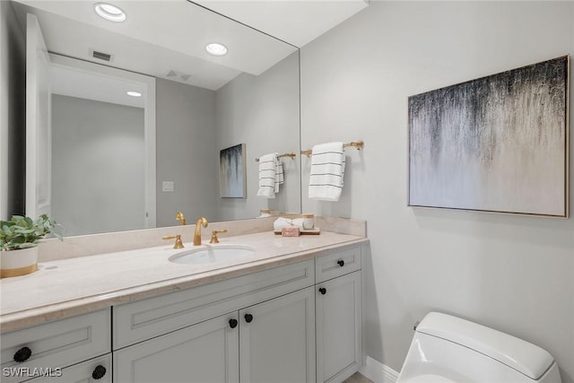 bathroom featuring vanity, toilet, recessed lighting, baseboards, and visible vents