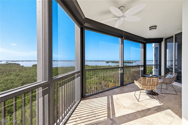 sunroom with a water view and ceiling fan