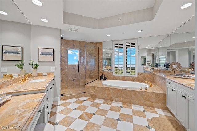 bathroom featuring vanity and independent shower and bath