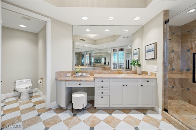 bathroom featuring toilet, vanity, and a shower with door