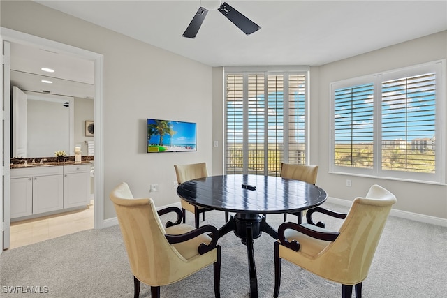 dining room featuring light carpet, sink, and ceiling fan