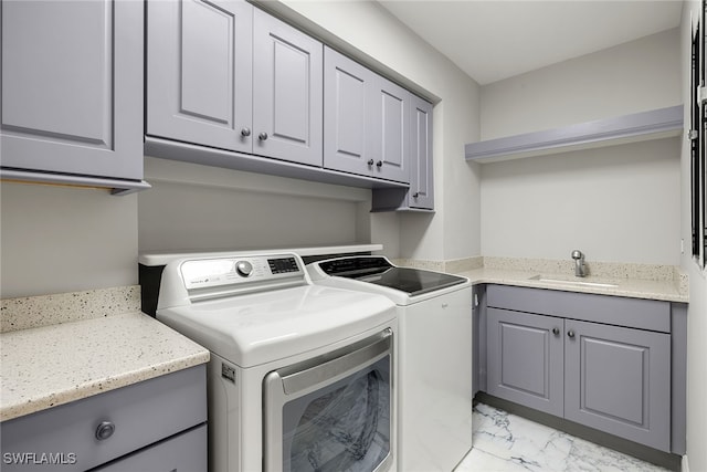 washroom featuring washer and dryer, cabinets, and sink