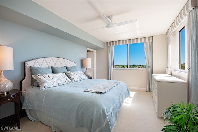 carpeted bedroom with multiple windows and ceiling fan