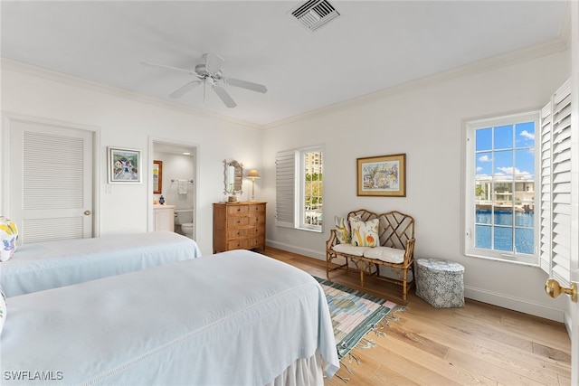 bedroom featuring ensuite bath, ornamental molding, light wood-type flooring, and ceiling fan