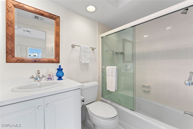 full bathroom with vanity, bath / shower combo with glass door, and toilet