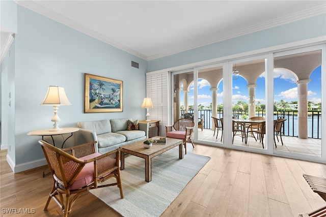 living room with ornamental molding, a water view, and light hardwood / wood-style floors