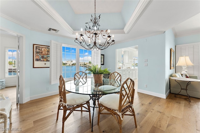 dining area with light hardwood / wood-style flooring, a healthy amount of sunlight, and a water view