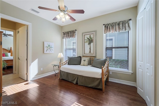 bedroom with dark wood-type flooring, a closet, and ceiling fan