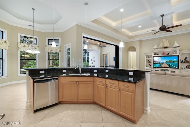 kitchen featuring dishwasher, dark stone countertops, a kitchen island with sink, and sink