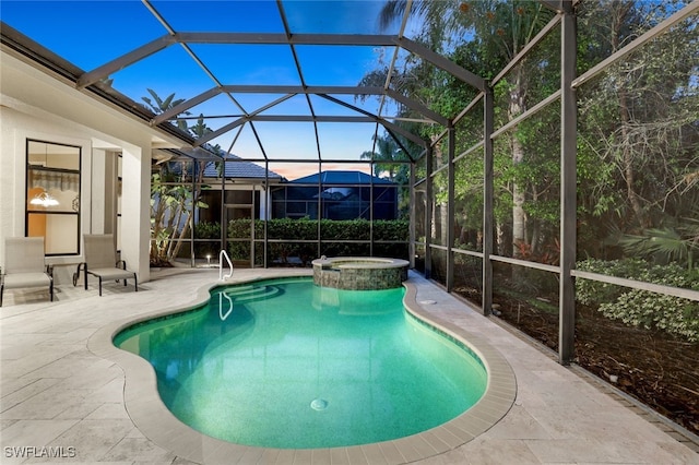 pool at dusk featuring an in ground hot tub, a patio, and glass enclosure