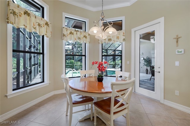 dining room with ornamental molding, an inviting chandelier, and light tile patterned floors