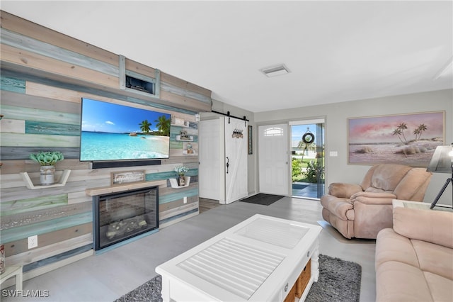 living room with wood walls and a barn door